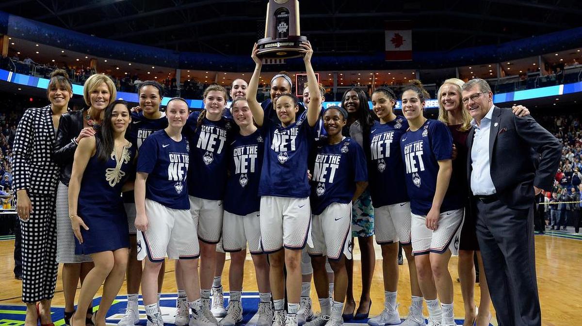 Connecticut’s Saniya Chong holds the trophy as she poses with her teammates following their 90-52 win over Oregon in a regional final game Monday in the NCAA women’s college basketball tournament in Bridgeport, Conn.