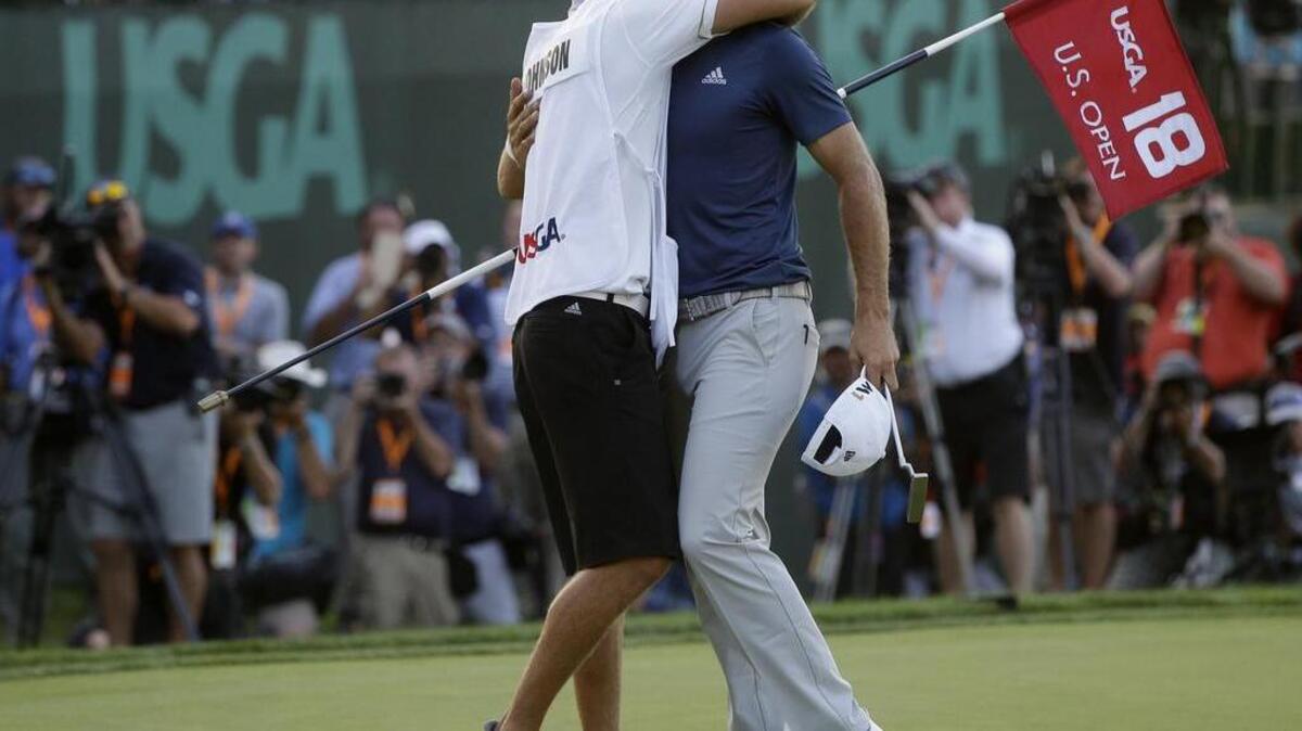 Dustin Johnson, right, hugs his caddie and younger brother Austin after making a birdie on the 18th hole during the final round of the U.S. Open golf championship at Oakmont Country Club on Sunday, June 19, 2016, in Oakmont, Pa. (AP Photo/John Minchillo)