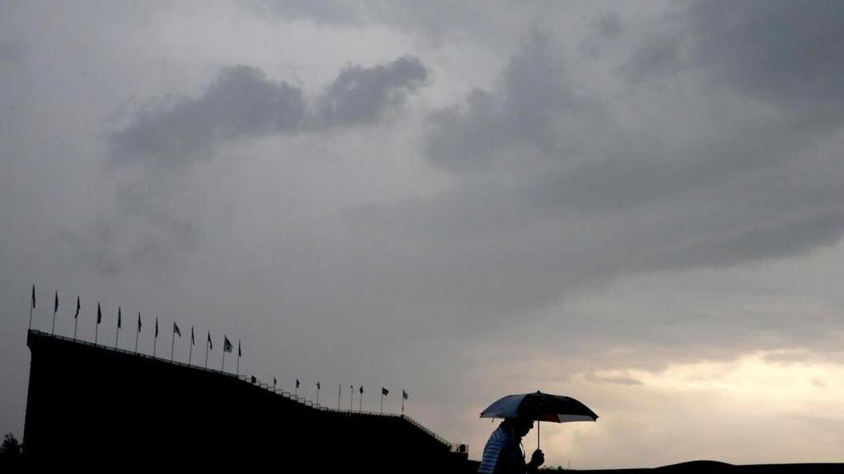 A fan leaves the course during the third rain delay.
