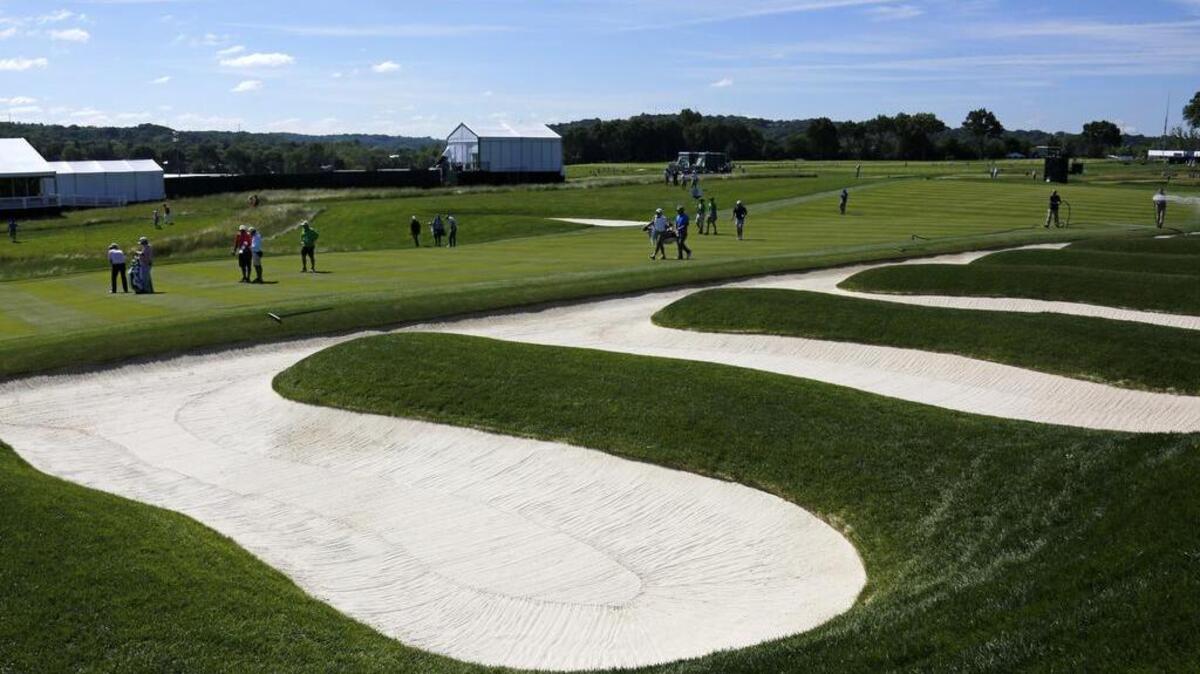Golfers walk up the 15th fairway past the Little Church Pews bunker, a small version of the famous Church Pews bunker between the third and fourth fairways, during a practice round for the U.S. Open at Oakmont Country Club on Monday.