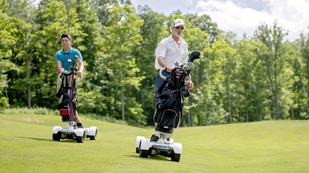 David Crawford leads the way to his ball as Hunter Schrock follows showing off the new Golfboards at Skytop Mountain Golf Course on Tuesday. The four-wheel Golfboards can speed up a round of golf and allow the golfer to get closer to the tees and greens.