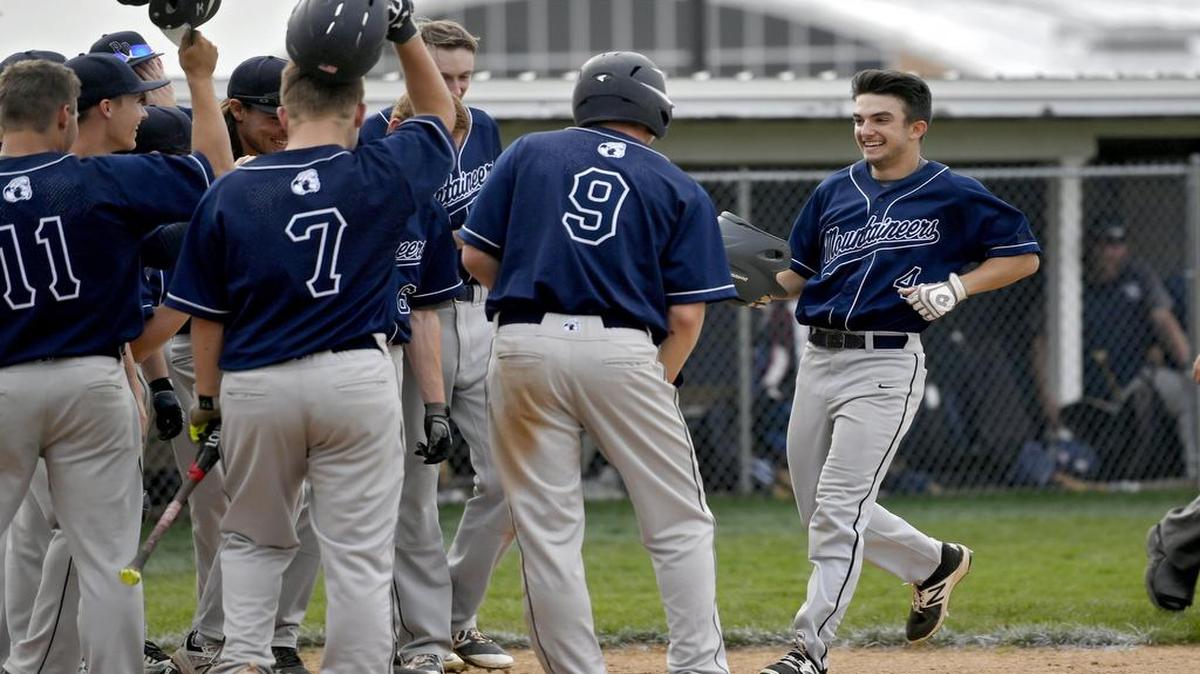 Philipsburg-Osceola's Logan Williamson takes off his helmet to be congratulated by his teammates after his homer during the game against Penns Valley on Thursday.