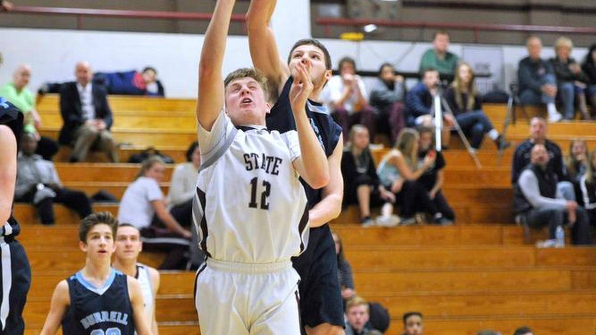 State College’s Drew Friberg (12) attempts a shot at the basket while a Burrell High School player attempts a block at the Kiwanis Holiday Basketball Classic on December 29, 2015.