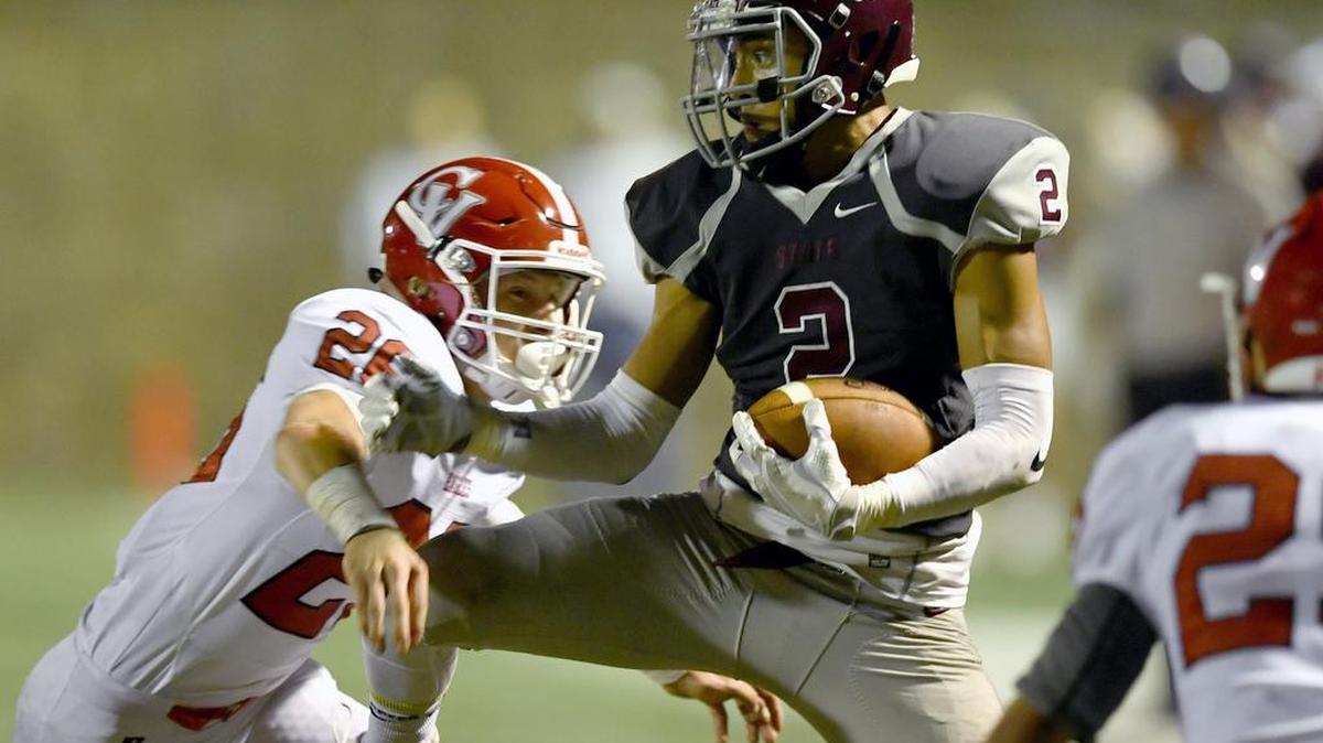 State College's Noah Woods makes a catch around Cumberland Valley's Jake Palmer during the Friday, October 7, 2016 game at Memorial Field. The Little Lions won 20-16.