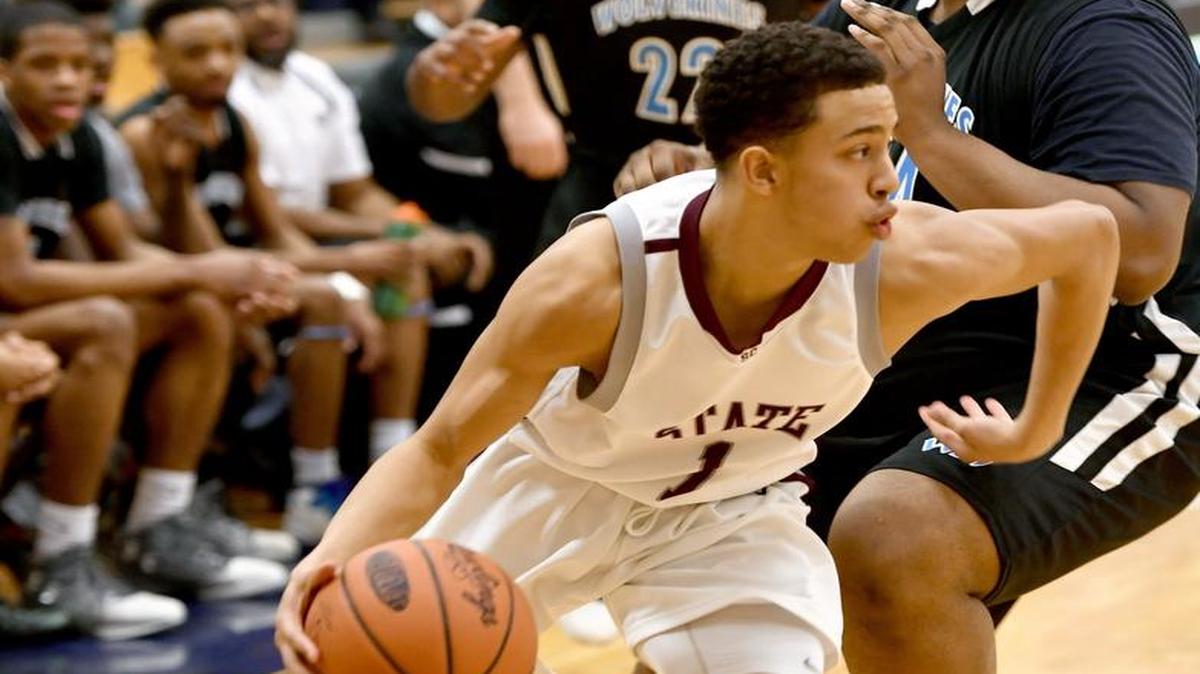 State College’s Keaton Ellis dribbles around a Woodland Hills defender during the state playoffs at Bald Eagle Area High School on Saturday, March 11, 2017. State College won 82-71.