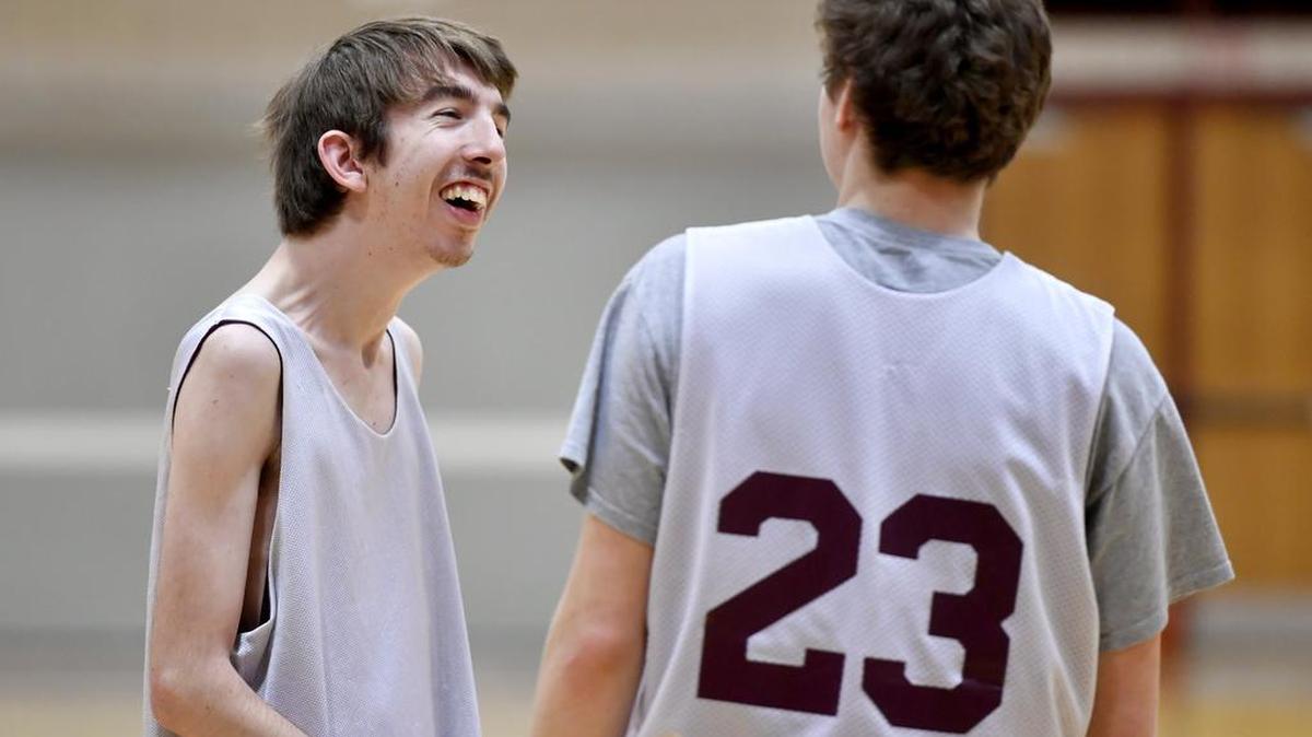 Jake Schildknegt laughs with Oliver Kile during State College boys’ basketball practice on Wednesday, January 18, 2017. Schildknegft is a student manager for the team.