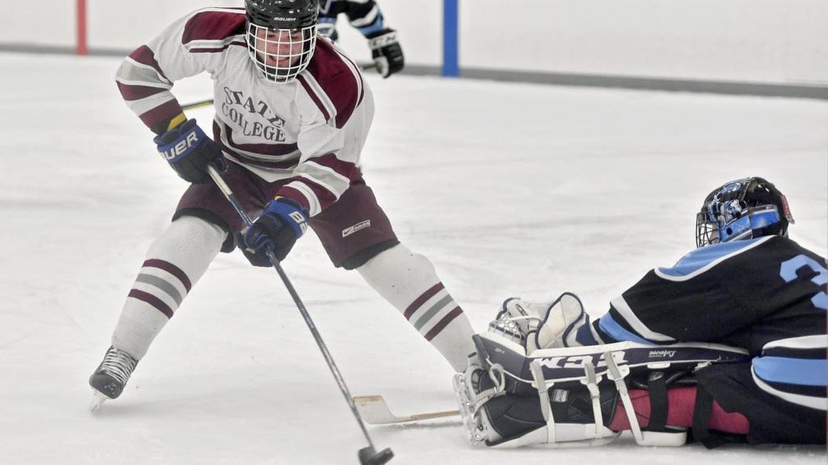 State College’s Michael Moscone, left, shoots the game-winning goal around Johnstown goalie Drew Pfiel with 34.4 seconds left during the Little Lions’ 5-4 win Thursday at Pegula Ice Arena.