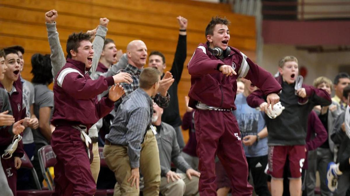State College wrestlers celebrate as Jackson Heasley gets the pin in the 220-pound bout to win the match 42-36 over Harrisburg on Thursday, January 25, 2018.