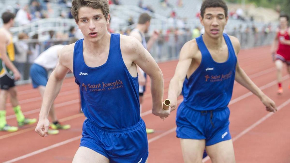 Saint Josephs’ Charles Ross hands off to Michael Peters for the final leg of the 4x800 meter relay during the District 6 AA Track and Field Championships on Tuesday. Saint Joseph’s came in first, and Philipsburg-Oseola came in third, both moving on to the PIAA State Championships.
