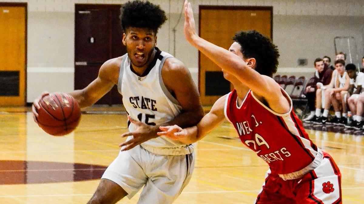State College’s Brandon Clark (15) moves the ball past Owen J. Roberts’ Sa’Vaughan David-Heiser in the Little Lions 82-63 win in the Kiwanis Holiday Classic on Wednesday night. Clark finished with 15 points in the victory.