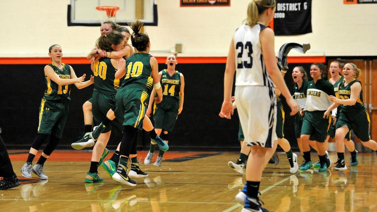The Marion Center girls celebrate their team’s victory as Penns Valley’s Mackenzie Ironside (23) walks off the court. The Penns Valley Area High School girls’ basketball team lost to Marion Center 34-33 in the District 6 playoffs on Feb. 23, 2016.
