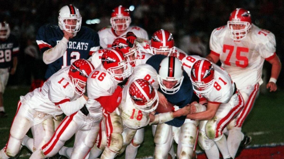 Huntingdon quarterback Paul Kozak is tackled by Bellefonte's Chad Rimmey (11), Craig Ripka (26), Nate Stone (18) and Curt Reese (81) in a District 6 playoff game in 1999. The Red Raiders upset Huntingdon 14-0 to reach the championship game.