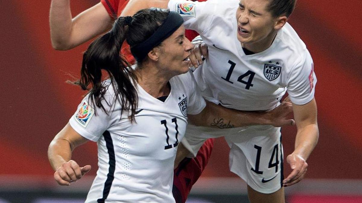 United States' Morgan Brian (14) lands on teammate Ali Kreiger (11) after crashing into Germany's Alexandra Popp, back, during the first half of a semifinal in the Women's World Cup soccer tournament, Tuesday, June 30, 2015, in Montreal, Canada. (Ryan Remiorz/The Canadian Press via AP)