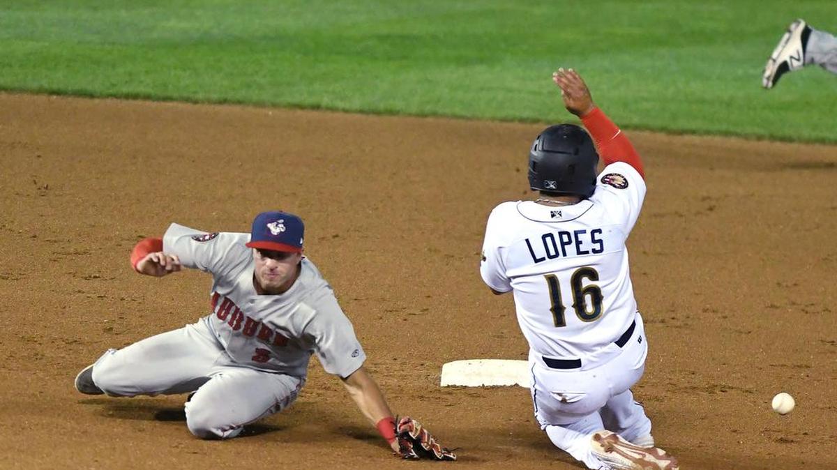 State College Spikes Caleb Lopes (16) slides safely into second base as Auburn second baseman Andres Martinez watches the throw go wide during Wednesday’s game in State College. The Spikes defeated Auburn 7-1.