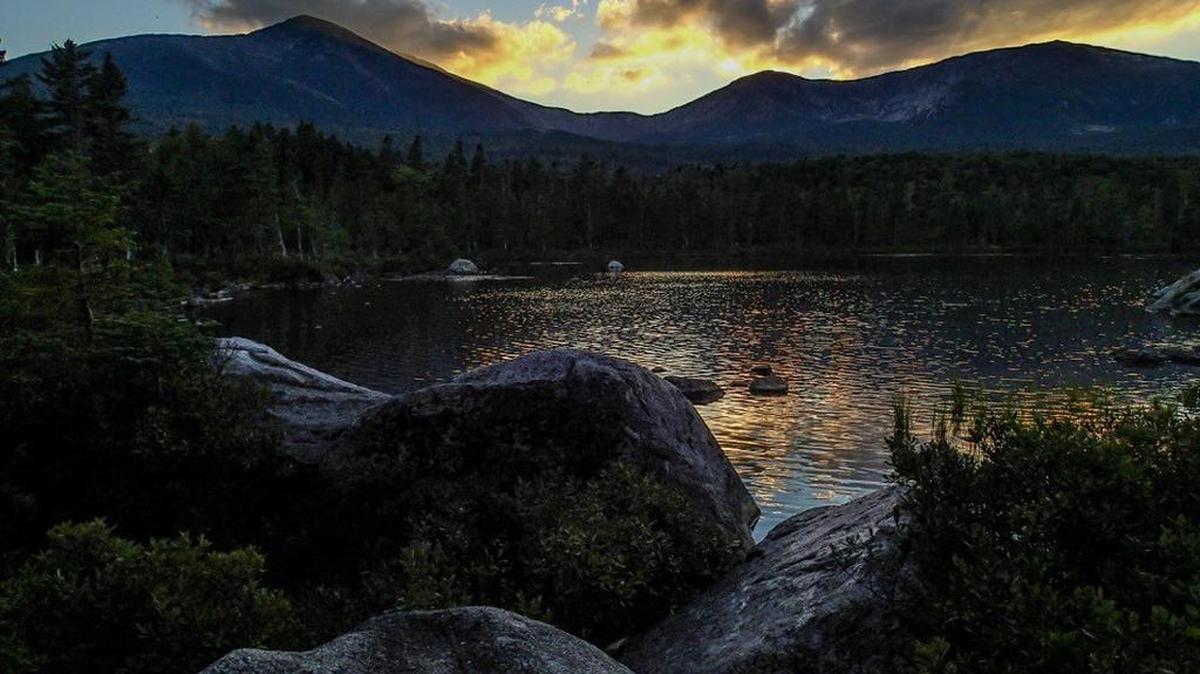 The sun sets behind Maine’s Mount Katahdin and Sandy Stream Pond.