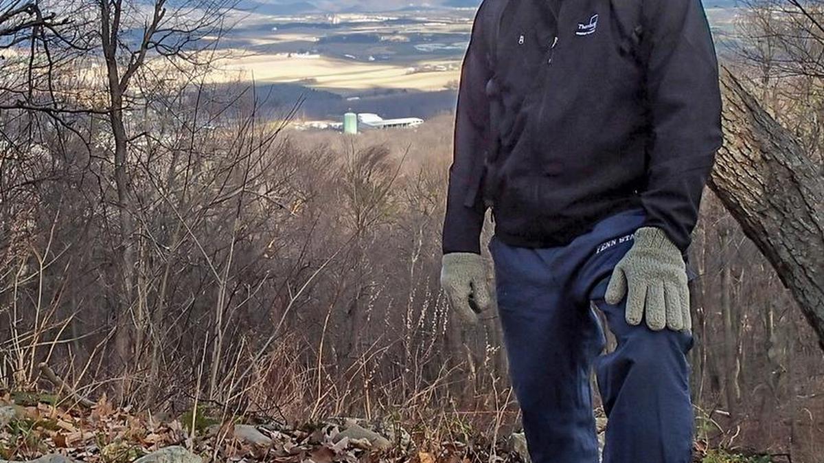 Eric Loop, a member of the Mount Nittany Conservancy Board of Directors and works on the mountain committee, stands at the Tom Smyth Overlook on top of Mount Nittany in December.