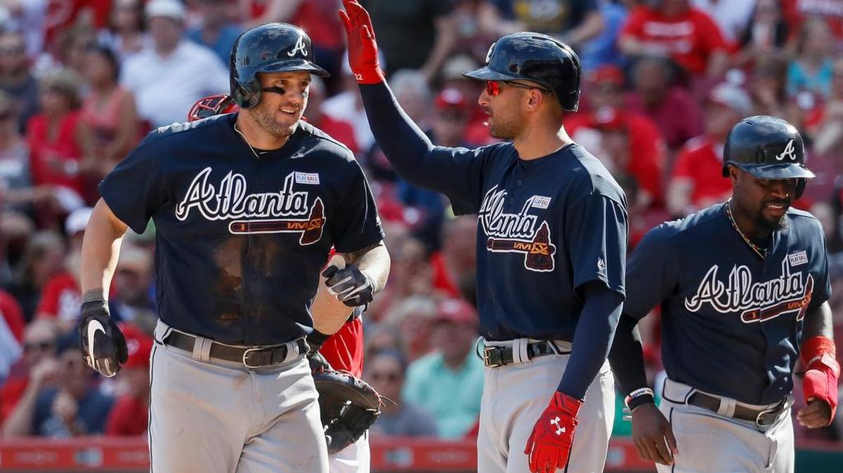 Atlanta Braves' and Philipsburg-Osceola native Matt Adams, left, celebrates with Nick Markakis, center, and Brandon Phillips, right, after hitting a grand slam off Cincinnati Reds starting pitcher Scott Feldman in the fifth inning of a baseball game, Saturday, June 3, 2017, in Cincinnati. (AP Photo/John Minchillo)