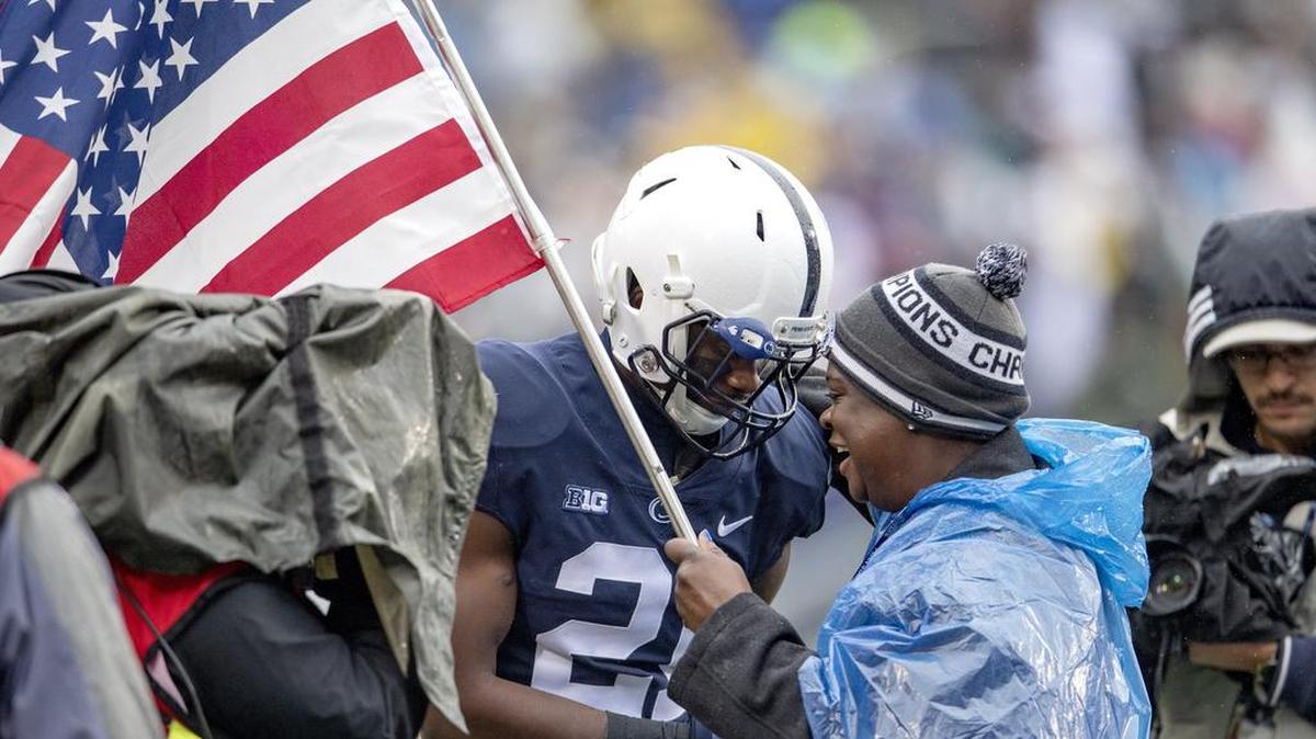 Penn State cornerback Amani Oruwariye hands his mom Karen the American flag that he ran onto the field with for the military appreciation game against Iowa game on Saturday, Oct. 27, 2018. Karen Oruwariye was in the Air Force and the Navy.